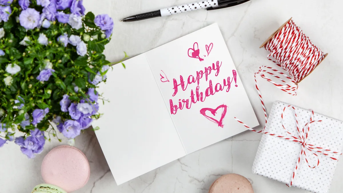 Birthday card, flowers, macarons, and a wrapped gift arranged on a table for Mom.